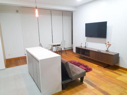 een woonkamer met een bank en een flatscreen-tv bij Apartamento Luz de Luna1 in La Paz