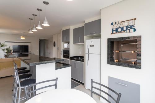 ピサーハスにあるEspaço amplo e confortável 3 Quartos, Churrasqueira, Cozinha completa, 180m da Praia, Wi-Fi, duas vagas de garagemのキッチン、リビングルーム(カウンター、椅子付)