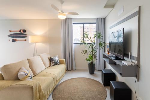 ピサーハスにあるEspaço amplo e confortável 3 Quartos, Churrasqueira, Cozinha completa, 180m da Praia, Wi-Fi, duas vagas de garagemのソファとテレビのあるリビングルーム