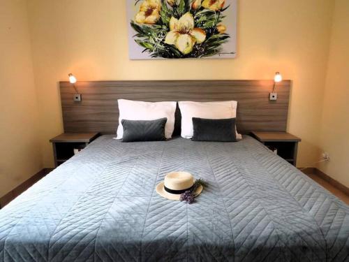 1 dormitorio con 1 cama con sombrero en French Country Villas, en Les Forges