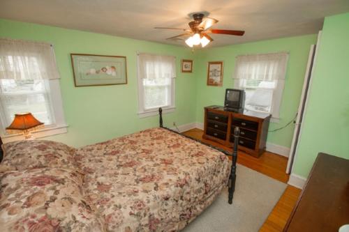 a bedroom with a bed and a dresser and a ceiling fan at Loraine's Retreat in Virginia Beach