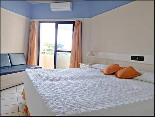 - une chambre avec un lit blanc et une fenêtre dans l'établissement Apartamento pé na areia - PRAIA BRAVA - FLORIANÓPOLIS, à Florianópolis
