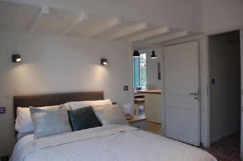 a bedroom with a large white bed with pillows at Gorgeous apartment superbly located in old town in Collioure
