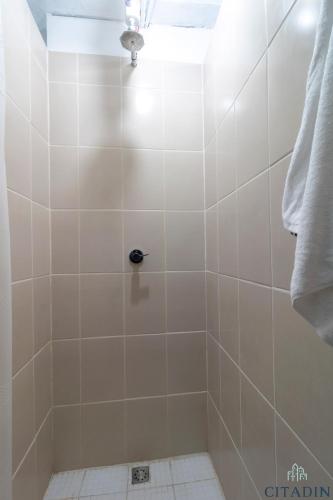 a bathroom with a shower with white tiles at Hotel Citadin Zona 4 in Guatemala