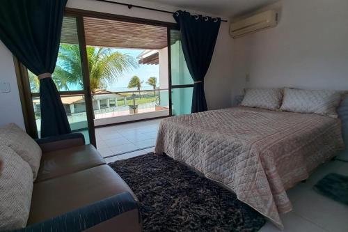 1 dormitorio con cama y ventana grande en Chalé na praia de Barreta, en Nísia Floresta