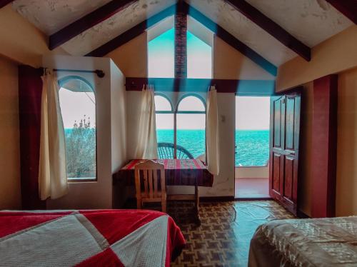 a bedroom with two beds and a view of the ocean at MIRADOR DEL INCA in Isla de Sol
