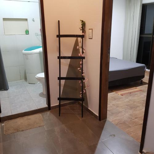 a bathroom with a toilet and a shelf with flowers at Xareu-Balanço das Ondas! in Cabo de Santo Agostinho