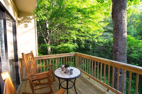 a porch with two chairs and a table on a deck at Pinetop Nest: Happy Place in Sugar Mountain in Banner Elk