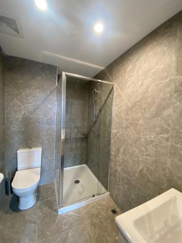 a bathroom with a shower and a toilet and a sink at La Quinta by Wyndham Ellerslie Auckland in Auckland