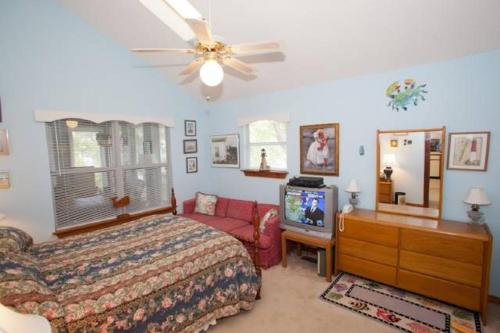 維吉尼亞海灘的住宿－Pelican Perch - North End VB，一间卧室配有一张床和一台电视。
