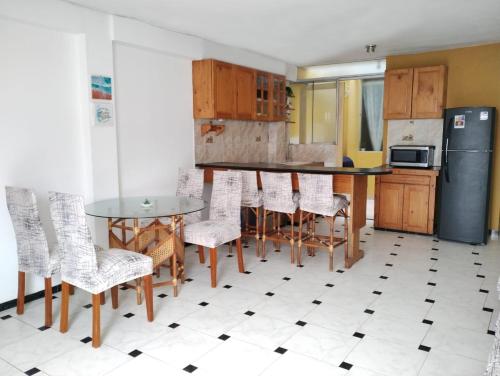 eine Küche mit einem Tisch und Stühlen sowie einem Kühlschrank in der Unterkunft Acogedor Departamento en la Playa in Punta Hermosa