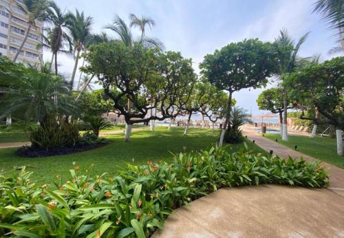 a park with trees and plants and a sidewalk at CAMELIA Y MAGNOLIA ACAPULCO in Acapulco