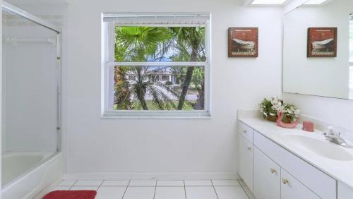 a white bathroom with a window and a sink at House Rosa Downtown in Cape Coral