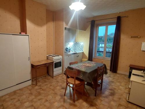 Il comprend une cuisine équipée d'une table et d'un réfrigérateur. dans l'établissement Les hortensias studio 6, à Bourbonne-les-Bains