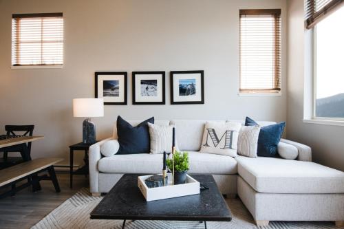 a living room with a couch and a table at New! Luxury, Top Floor, Ski in/Ski Out, Private Hot Tub and Mountain Views in Sun Peaks