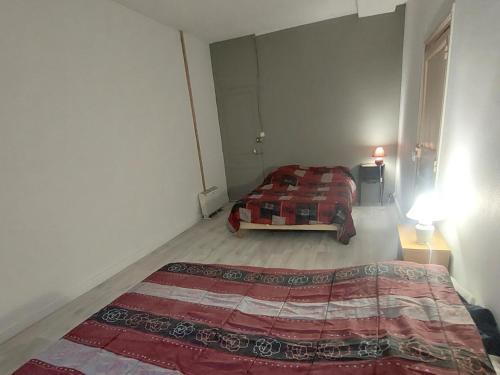 a bedroom with a bed in the corner of a room at Les hortensias studio 6 in Bourbonne-les-Bains