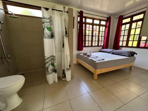 a bedroom with a bed and a shower and a toilet at GuestHouse PAPEN'S HOUSE 