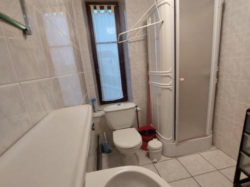 a bathroom with a tub and a toilet and a sink at Les hortensias studio 6 in Bourbonne-les-Bains