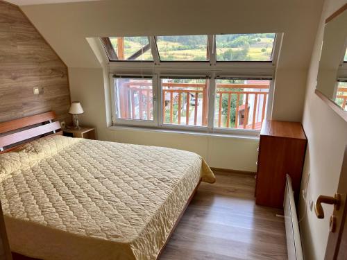 a bedroom with a bed and a large window at Alpine Nest: 6km to ski slopes in Beli Iskar