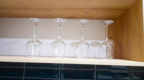 uma fila de copos de vinho sentados numa prateleira em Apartamento Luz de Luna2 em La Paz