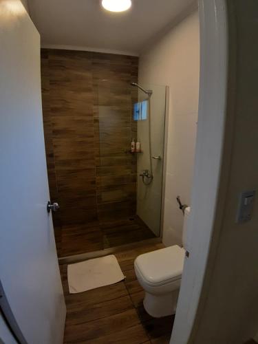 a bathroom with a toilet and a glass shower at Hotel Terrazas del rio Negro in Pueblo Centenario