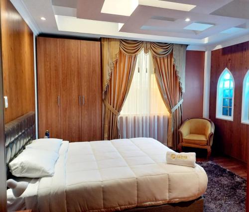 a bedroom with a large bed and a window at Hotel Troya in Ibarra