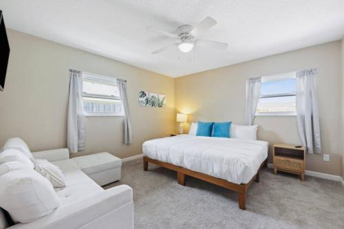 um quarto com uma cama branca e um sofá branco em Paradise Found Luxurious Retreat with Heated Pool em Rockledge