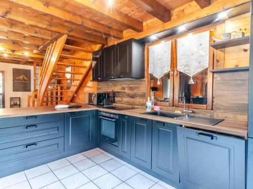 Il comprend une cuisine avec des placards bleus et un plafond en bois. dans l'établissement Chalet de charme 4 ch, garage & cheminée - Morzine - FR-1-754-16, à Morzine