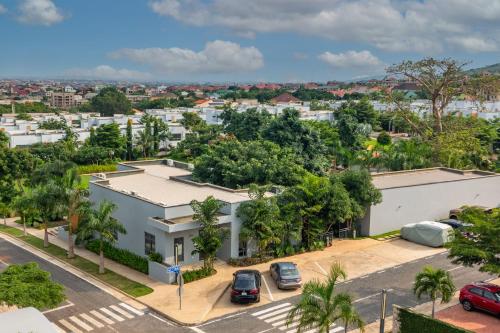 una vista aérea de un edificio blanco con coches aparcados en un aparcamiento en Contemporary 1 bedroom with pool, en Accra