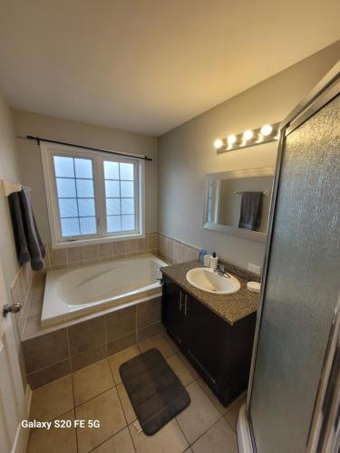 a bathroom with a bath tub and a sink at Three-room townhouse in Ottawa