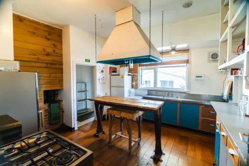 a kitchen with a wooden table and a blue island at Pinedale Lodge & Apartment in Methven