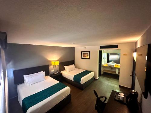 a hotel room with two beds and a bathroom at InHouse Hotel Obregón in Ciudad Obregón