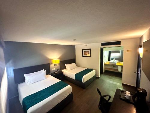 シウダード・オブレゴンにあるInHouse Obregónのベッド2台とバスルームが備わるホテルルームです。