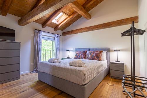 een slaapkamer met een groot bed en een raam bij Corte Barattina - Antica Dimora Tra Campagna e Città in Trebbo Di Reno