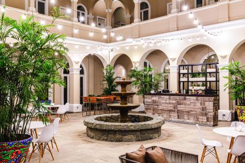 a lobby with a fountain and tables and chairs at LP Los Portales Hotel Piura in Piura
