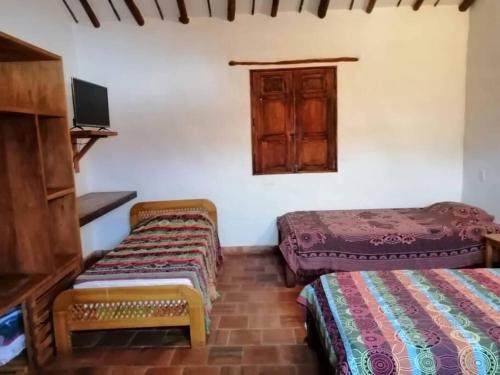 a room with two beds and a window at Casa en Barichara: la perfección hecha realidad! in Barichara