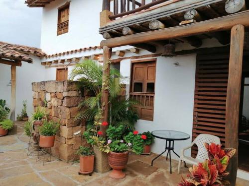 a patio with potted plants and a table and a building at Casa en Barichara: la perfección hecha realidad! in Barichara