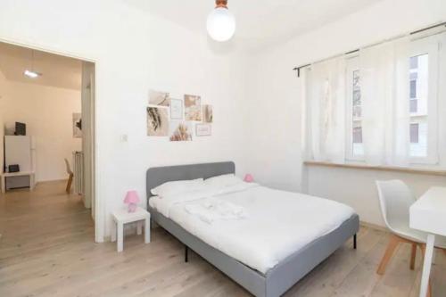 a white bedroom with a bed and a table at city flat [strategic position] in Turin