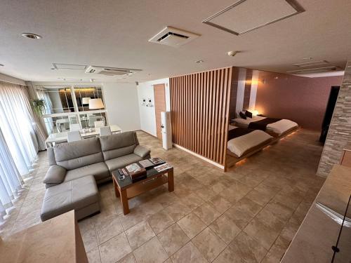 豊中市にあるHOTEL felice Osaka -伊丹空港-のソファとベッドのあるリビングルーム