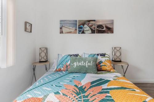 a bed with a colorful comforter and two pictures on the wall at Island Vibes 1 bedroom in LongBeach-30 days min. in Long Beach