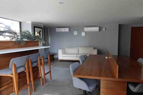 een woonkamer met een tafel en stoelen en een bank bij Super cómodo depa con alberca! in Guadalajara