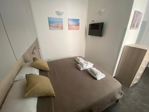 ein Schlafzimmer mit einem Bett mit zwei Handtüchern darauf in der Unterkunft Little House in Reggio di Calabria