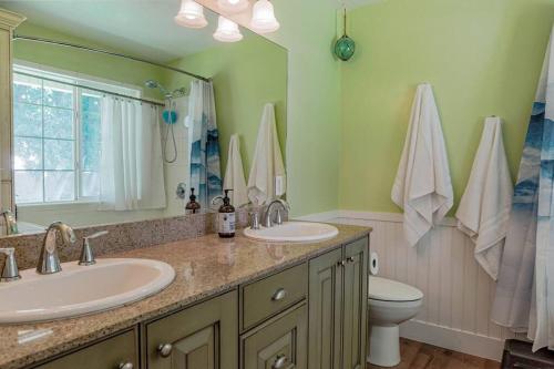a bathroom with two sinks and a mirror and a toilet at Roller Mills Retreat - 16+ in Lehi