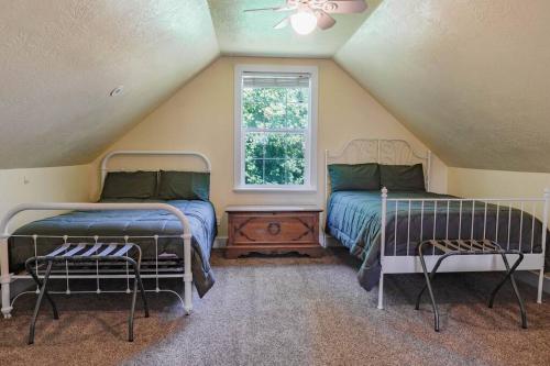 a attic bedroom with two beds and a window at Roller Mills Retreat - 16+ in Lehi