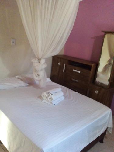 - une chambre avec un lit, des serviettes et un miroir dans l'établissement Casa pé na areia ao lado de Mangue Seco, à Jandaíra