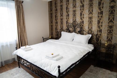 a bedroom with a bed with two white towels on it at Central Parc Apartment 6 ! Self Check-in ! Free Parking ! WiFi in Suceava
