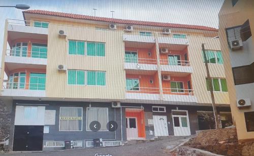 an apartment building with orange doors and windows at Secularis Capital in Praia