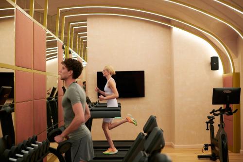 a man and woman running on treadles in a gym at W Budapest in Budapest