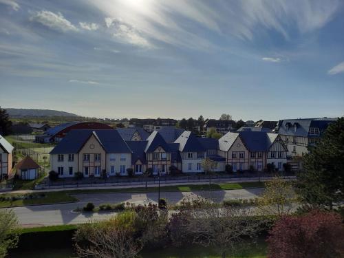 un gruppo di case in una città con il sole nel cielo di Mer et Soleil à Blonville sur mer/ Deauville a Blonville-sur-Mer