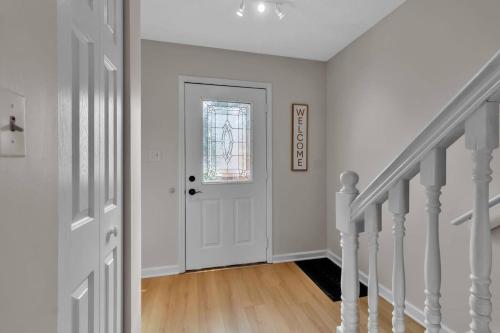 a white hallway with a white door and stairs at Downtown & Upscale in Buffalo